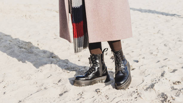 Stylish ankle boots in outdoor on the sand beach