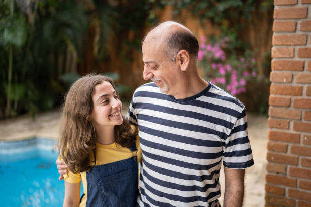 istock Father and daughter looking at each other at home 1339629722
