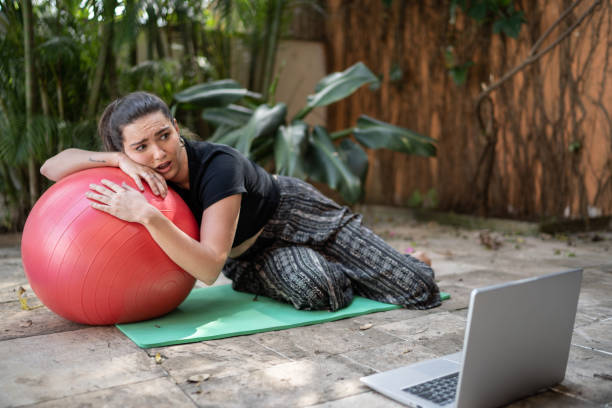 young tire woman working out during virtual exercise class at home - non moving activity imagens e fotografias de stock