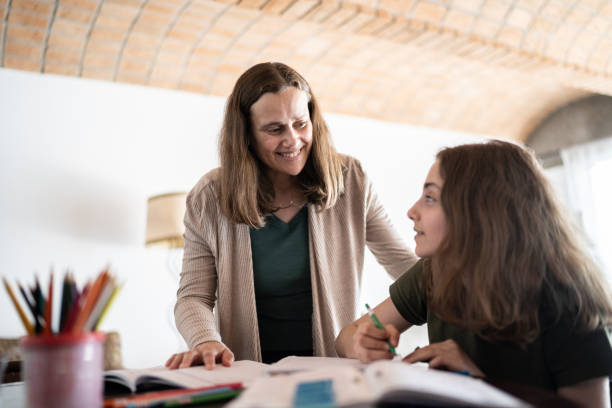 istock Mother helping daughter with homework at home 1339631027