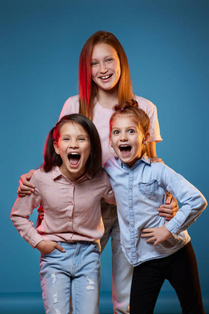 istock three kids girls standing together on blue background 1339631756