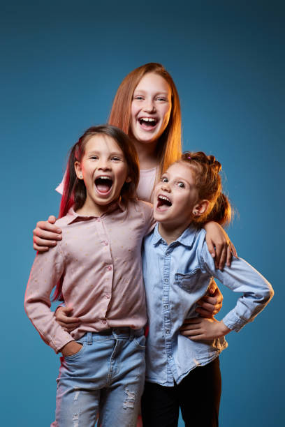istock three kids girls standing together on blue background 1339631762