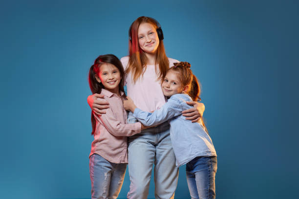 istock three kids girls standing together on blue background 1339632321