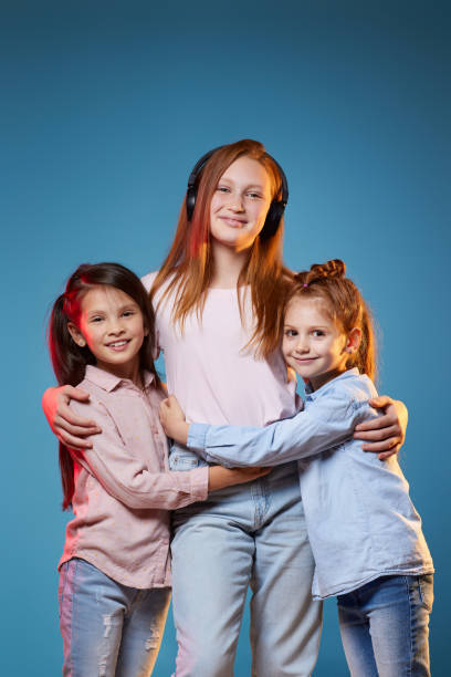istock three kids girls standing together on blue background 1339632342