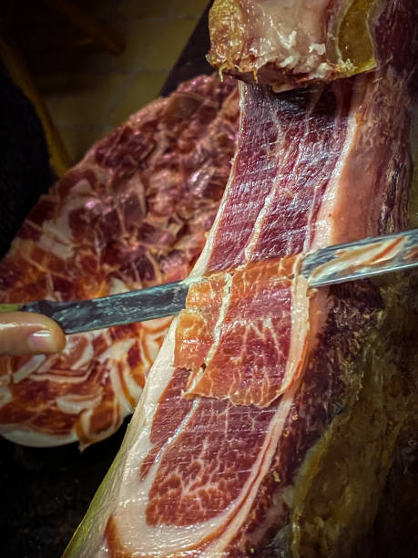 istock People cutting iberian ham dish in house. 1339634512