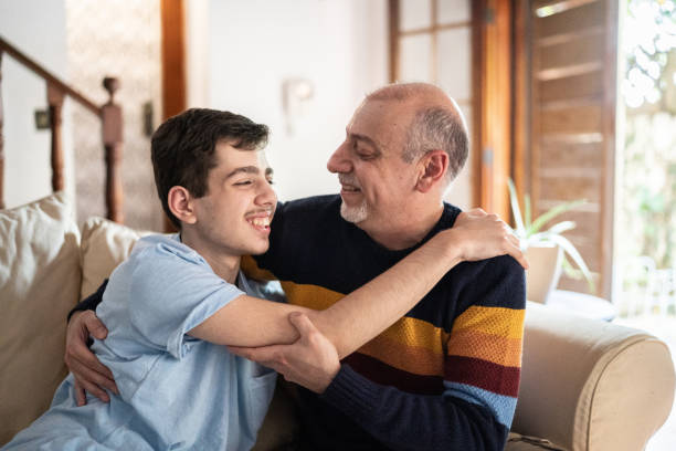 padre e hijo abrazándose en casa - autism fotografías e imágenes de stock