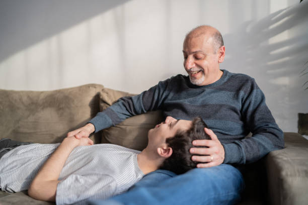istock Son laying on father's lap at home 1339635325