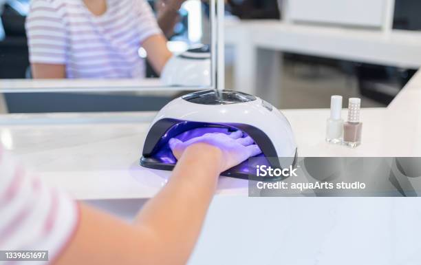 Female Customer Putting Hand İnto Uv Lamp Dryer İn Beauty Salon Stock Photo - Download Image Now
