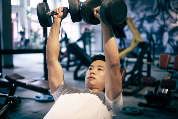 istock Man lifting dumbbells in the gym 1339653610