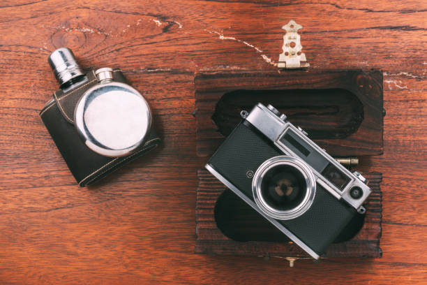 istock Still life leather, silver hip flask, old camera and dark wood box on wooden surface 1339654769