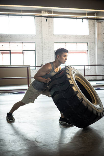 Man flipping tire in a gym