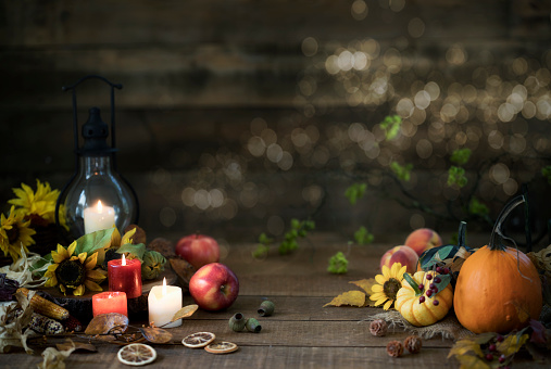 Autumn pumpkins, gourds and holiday decor arranged against an old wood background