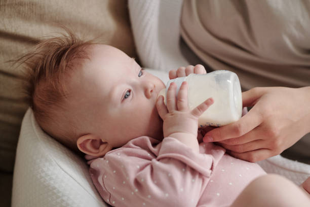 istock Cute toddler girl eating milk while holding bottle 1339656309