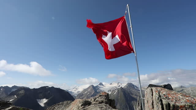 Scenic view of Swiss flag flying from mountain crest