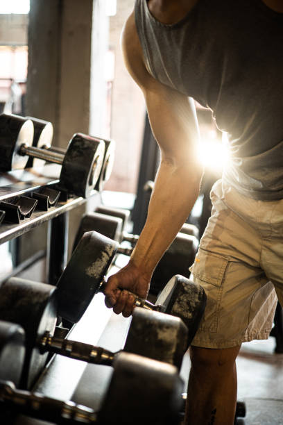 istock Man taking weights from in a gym 1339657775