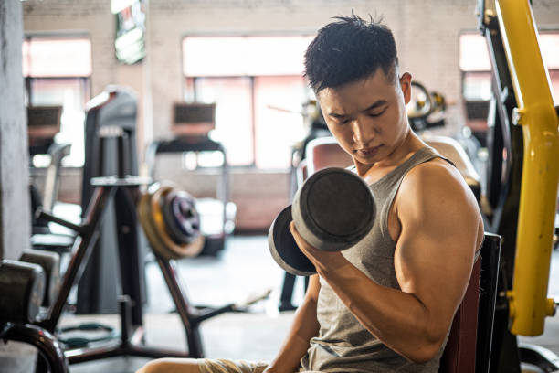 Using dumbbell at gym stock photo