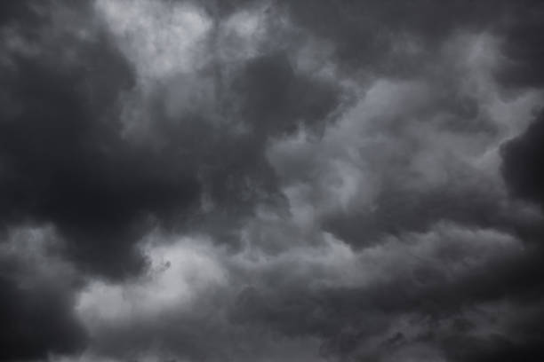 dramatischer himmel mit schwarzen stürmischen regenwolken - lowering sky stock-fotos und bilder