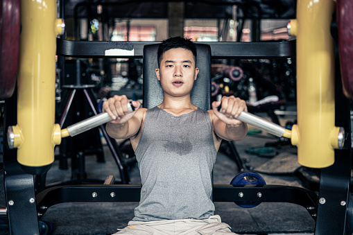 asian man works out in modern gynm