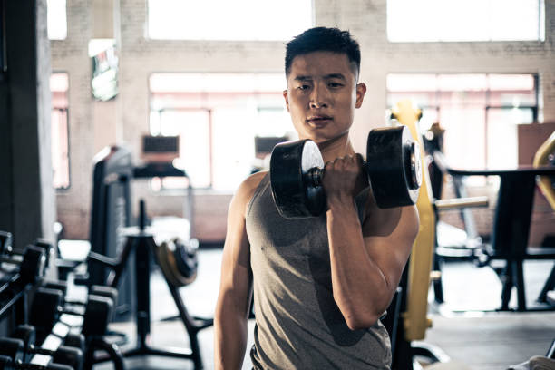 istock man doing exercise with dumbbell in gym 1339660017