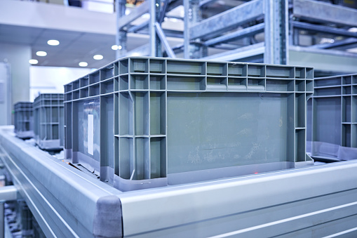 Side view of plastic crates at conveyor belt.