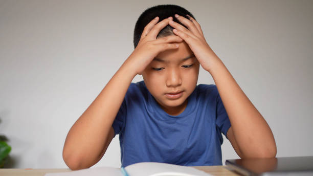 istock slow motion scene asian boy headache after reading books for midterm or final test at home and using hand massage for relief symptom during lockdown time for healthcare lifestyle concept 1339668966