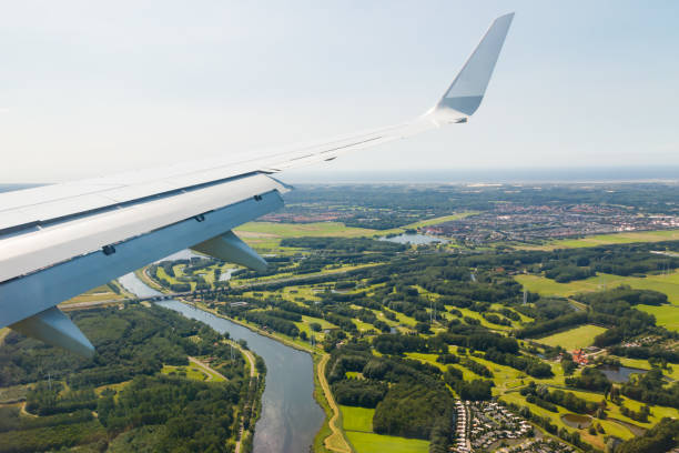 plain wing over holland. flight from helsinki to amsterdam. - schiphol stockfoto's en -beelden