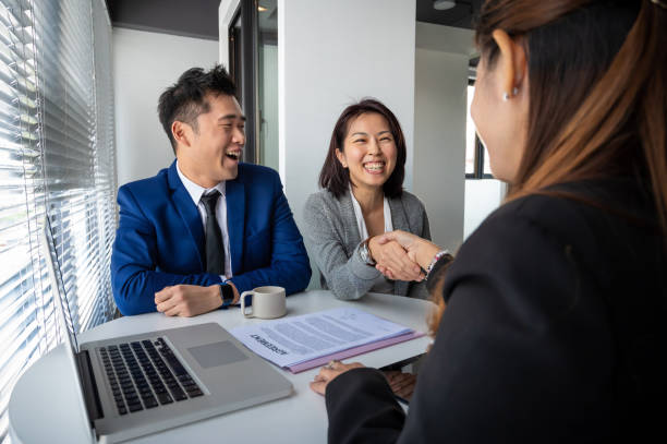 asian business partners shake hands with female financial consultant after successful business deal in the meeting room. - cheering business three people teamwork imagens e fotografias de stock