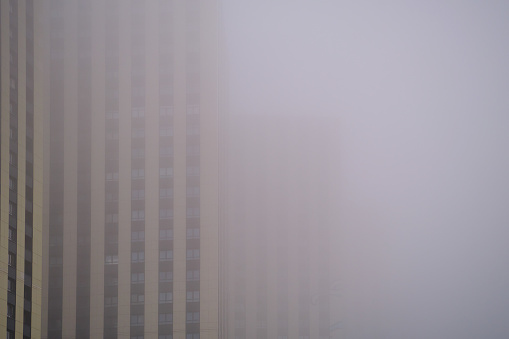 Windows on the facades of high-rise apartment buildings, fog close-up