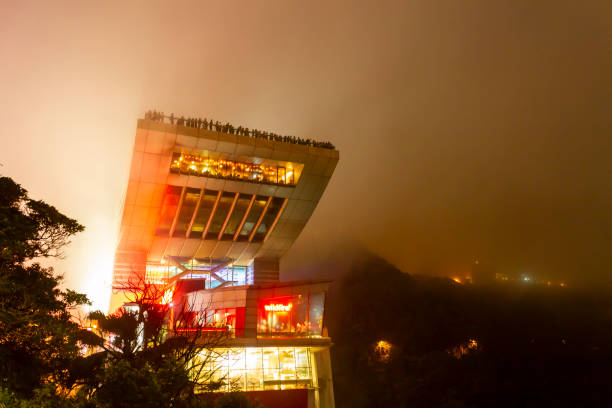 a torre peak no pico victoria em foggy night na ilha de hong kong. - hong shopping night skyline - fotografias e filmes do acervo