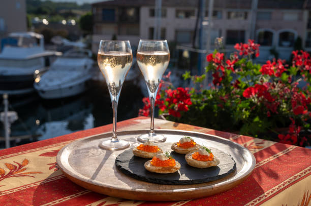 russian style party with two glasses of white cold champagne, bliny with red caviar and view on port grimaud near saint-tropez in summer - dining nautical vessel recreational boat europe imagens e fotografias de stock