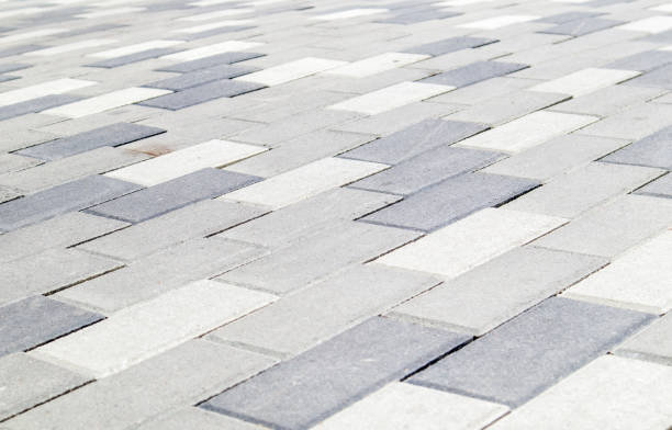 Concrete or paved newly laid gray paving slabs or stones for floors or walkways. Concrete paving slabs in the backyard or road paving. Garden brick path in the courtyard on a sandy foundation losas o piedras de pavimento gris recién colocadas de concreto o pavimentadas para pisos o pasarelas. losas de pavimento de hormigón en el patio trasero o pavimentación de carreteras. camino de ladrillo de jardín en el patio sobre una base de arena