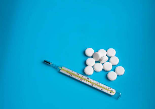 istock thermometer and white pills on the blue background 1339674784