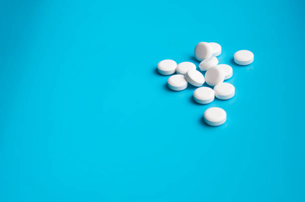 istock whte pills or tablets for virus on blue background 1339674933