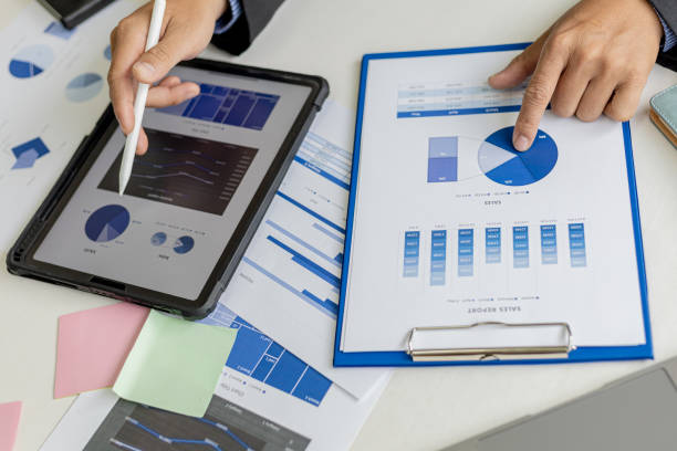 istock Businessman is using tablet to compare information on financial documents, he is checking company financial documents in office, company financial statements. Concept of financial management. 1339675356
