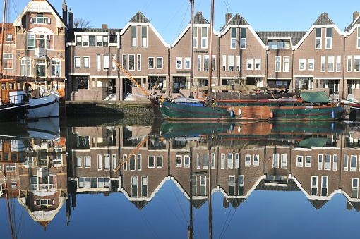 View on houses and sailing boats reflecting in the water.