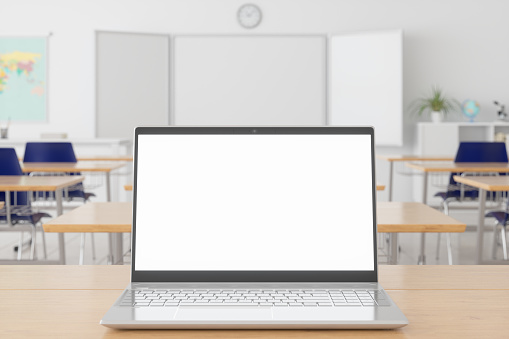 Computadora portátil con pantalla en blanco en el escritorio de madera y fondo borroso del aula vacía photo