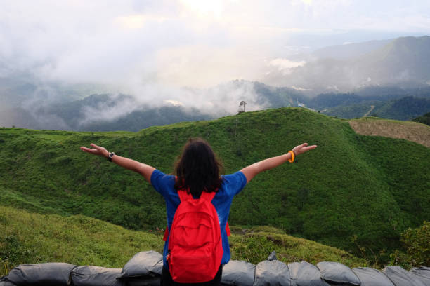 la mujer asiática está abierta a las manos para el destino y el paraíso del amanecer dorado y el atardecer brillando ante la niebla y la niebla en la jungla en la montaña del valle. vista aérea de la selva tropical en tailandia. - heaven women sunrise inspiration fotografías e imágenes de stock