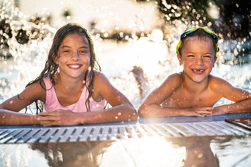 Children having fun swimming in the river on a hot summer day