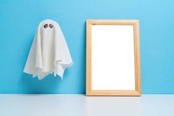 an abstract ghost next to a wooden frame with copy space. halloween holiday. - material data sheets imagens e fotografias de stock