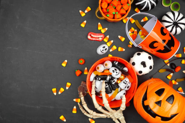 istock Halloween trick or treat side border with jack o lantern pails and candy on a black background 1339689623