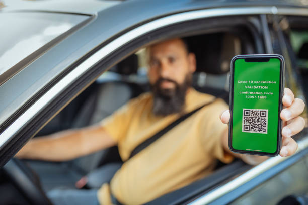 istock Mature man showing immunisation certificate while driving car 1339691465
