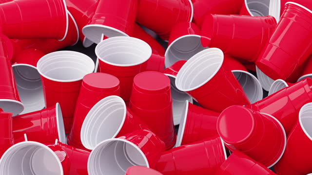Closeup shot of stacks of red and green plastic cups isolated on a