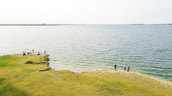 Aerial view group of Asian men fishing at Lavon Lake, Texas, America. Fresh water fishing from the sand cliff.