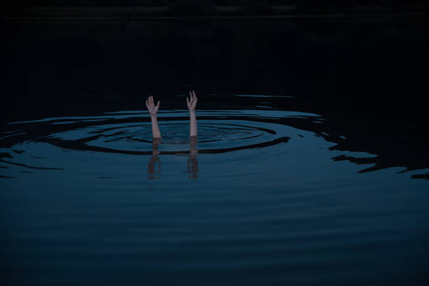istock Woman drowning in a water at night. 1339704903