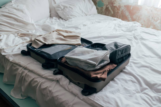 istock An open packed suitcase on a messy bed in light colors 1339709831