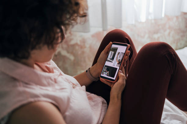 A Caucasian woman looking at her phone from behind
