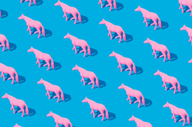 Collage of pink rubber horses isolated on blue background.