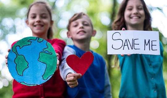 Three cute kids are saying save the planet Earth
