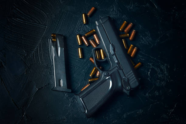 istock Pistol with cartridges on black concrete table. 1339721181