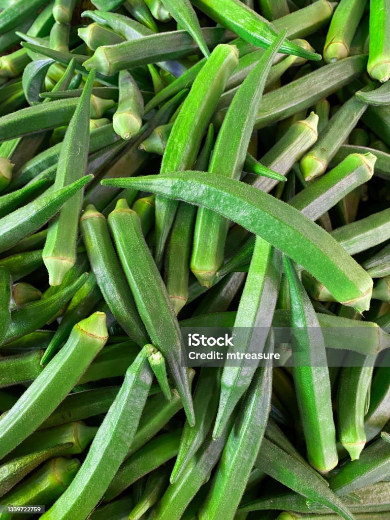 Full frame image of produce market pile of fresh green Okra (Abelmoschus esculentus) being sold at an outdoor fruit and vegetable market, elevated view Stock photo showing a elevated view of a pile of Okra (Abelmoschus esculentus) being sold at an outdoor fruit and vegetable market. Okra is commonly known as ladies' fingers or ochro. Okra Stock Photo